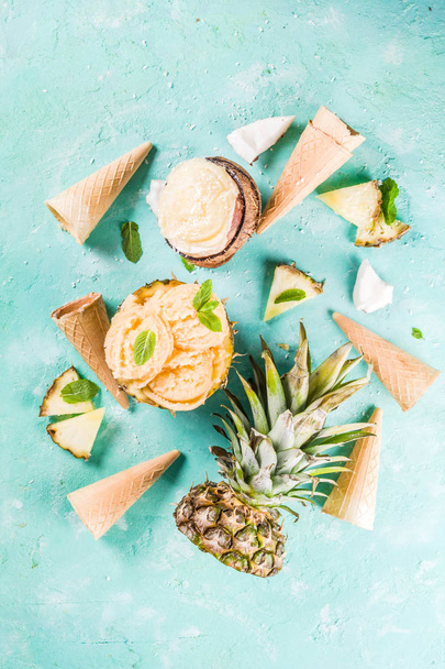 Summer holiday vacation concept, set various tropical ice cream sorbets, frozen juices in pineapple, grapefruit and coconut, light blue concrete background copy space - Foto, Imagen