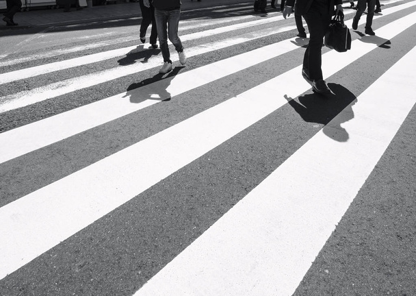 Cross walk with people walking Shadow on urban road traffic sign
  - Фото, изображение