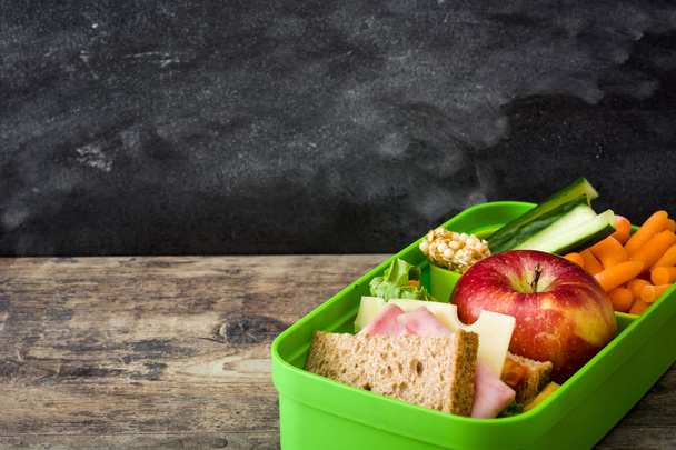 Healthy school lunch box: Sandwich, vegetables and fruit on wooden table. Copyspace - Photo, Image