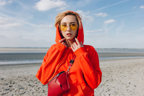 hermosa chica con capucha roja de pie en la playa, monte santo michaels, Francia
 - Foto, imagen