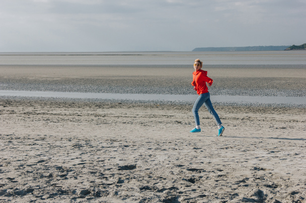 elegáns lány fut a homokos strandon, Saint michaels mount, Franciaország - Fotó, kép