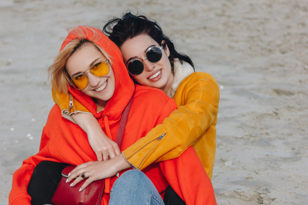 happy girls hugging and sitting on beach, Saint michaels mount, Normandy, France - Foto, afbeelding