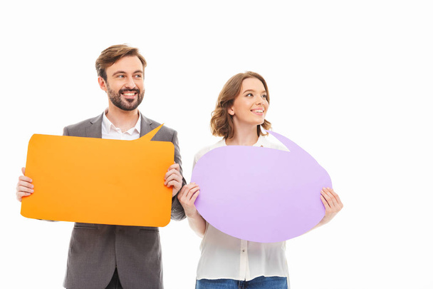 Portrait of a confident young business couple holding empty speech bubbles isolated over white background - Photo, image
