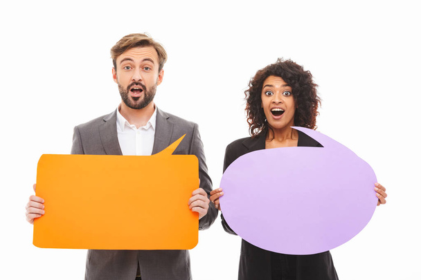 Portrait of a happy young business couple holding empty speech bubbles isolated over white background - Foto, Imagem