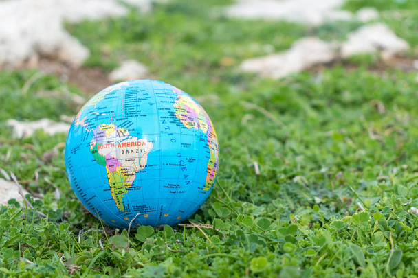 Small globe in the grass. Travel and global issues concept. - Foto, Bild