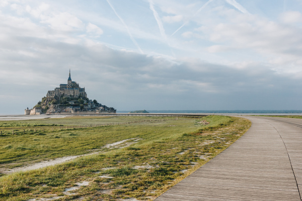 schöne Aussicht auf den berühmten mont Saint Michel und Promenade an der Meeresküste, Normandie, Frankreich   - Foto, Bild