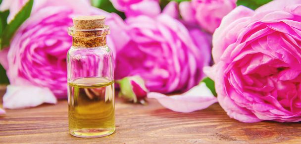Essential oil of rose on a light background. Selective focus.  - Photo, Image