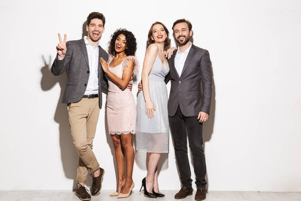 Group of happy well dressed multiracial people standing together isolated over white background - Foto, afbeelding