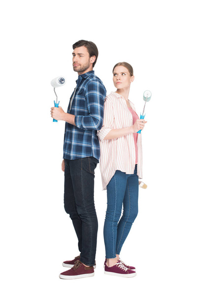 couple with paint rollers standing back to back isolated on white background  - 写真・画像