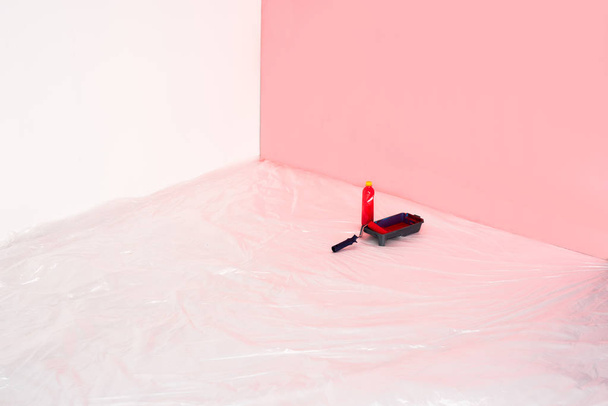 close up view of bottle, roller tray and paint roller in front of painted wall  - Foto, Imagen