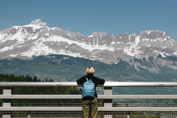 rear view of young woman with backpack looking at majestic snow-capped mountains, mont blanc, alps - Фото, изображение