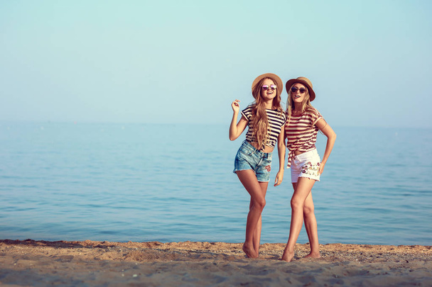 два європейських дівчаток весело влітку на пляжі - Фото, зображення