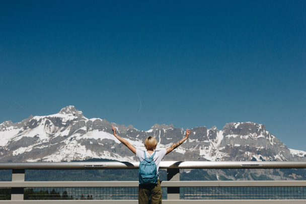 vista trasera de chica con mochila levantando las manos y mirando majestuosas montañas cubiertas de nieve, mont blanc, alpes
 - Foto, imagen