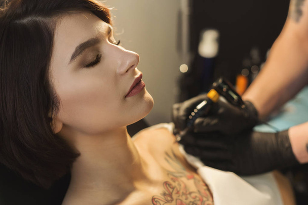 Tatuagem artista trabalhando com agulha no corpo dos clientes
 - Foto, Imagem