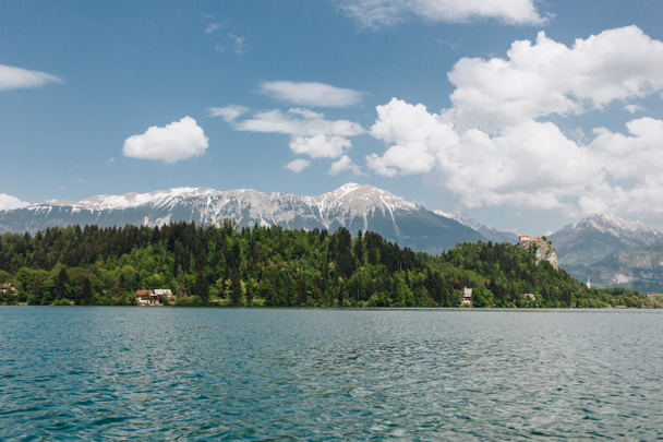 美しい雪に覆われた山々 の峰、緑豊かな植生と穏やかな湖、ブレッド、スロベニア - 写真・画像