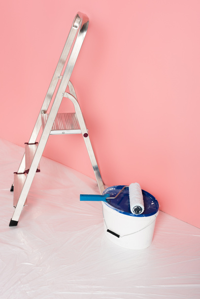 vista de cerca del rodillo de pintura en lata de pintura y escalera delante de la pared pintada
  - Foto, Imagen
