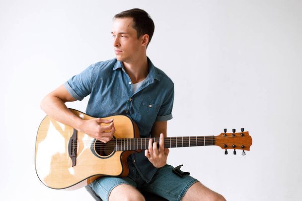 Bonito e alegre músico cara em uma camisa tocando guitarra
 - Foto, Imagem