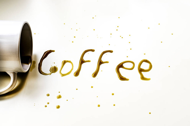 Filiżanka kawy leżące z kawy słowo napisane z kawy na białym tle. - Zdjęcie, obraz