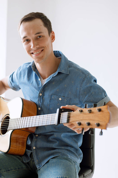 beau et joyeux gars musicien dans une chemise jouer de la guitare
 - Photo, image