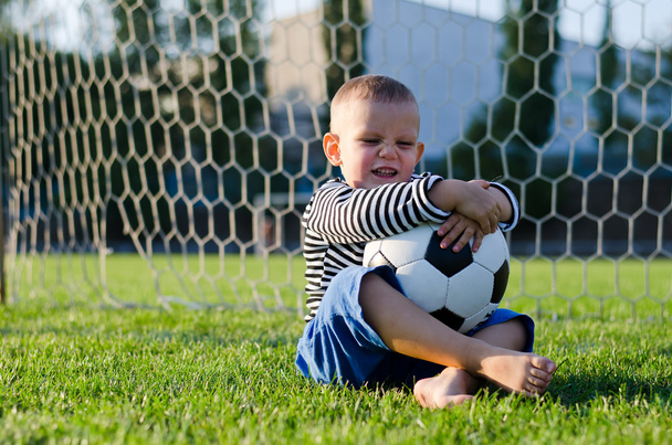 Riéndose niño con su pelota de fútbol
 - Foto, Imagen