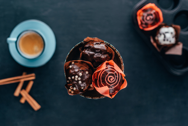 vista dall'alto di dolci cupcake con gocce di cioccolato serviti con caffè nero
  - Foto, immagini