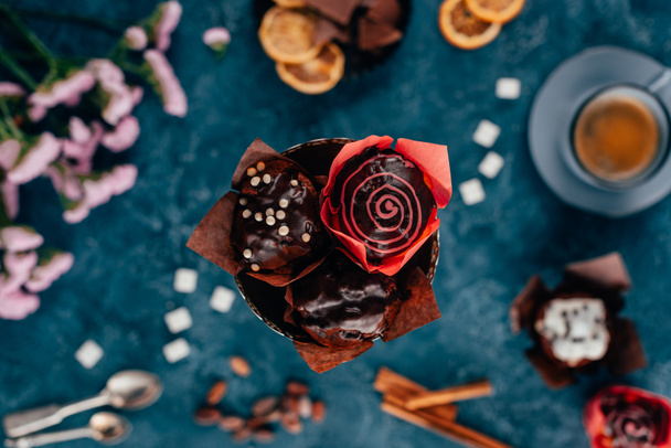 Draufsicht auf Schokoladenmuffins und Tasse Kaffee auf blauem Hintergrund - Foto, Bild
