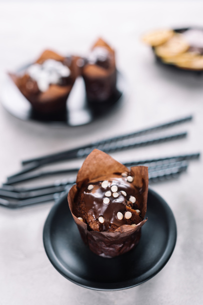 Sweet cupcakes with chocolate chips on light table - Foto, afbeelding