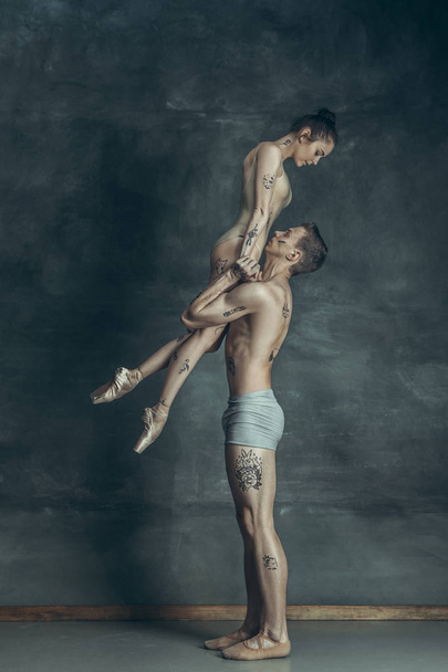 The young modern ballet dancers posing on gray studio background - Foto, afbeelding