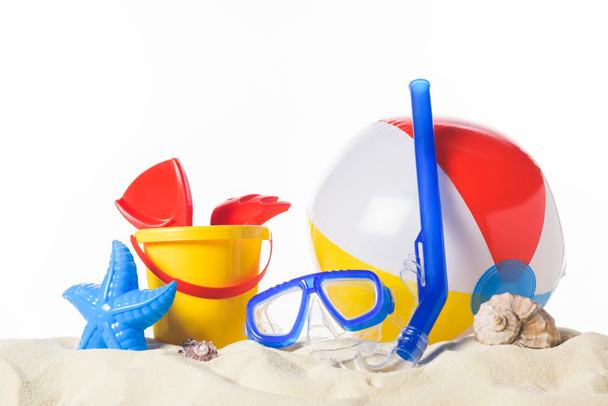 Máscara de buceo con pelota de playa y juguetes en arena aislada en blanco
 - Foto, Imagen
