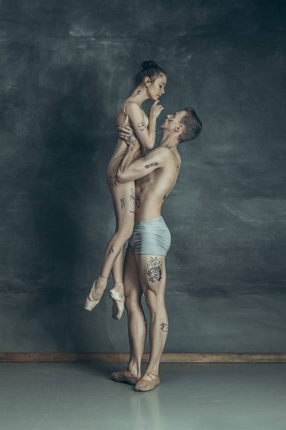 The young modern ballet dancers posing on gray studio background - Φωτογραφία, εικόνα