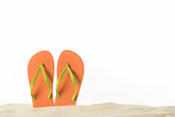 Pair of flip flops in sand isolated on white - Photo, Image