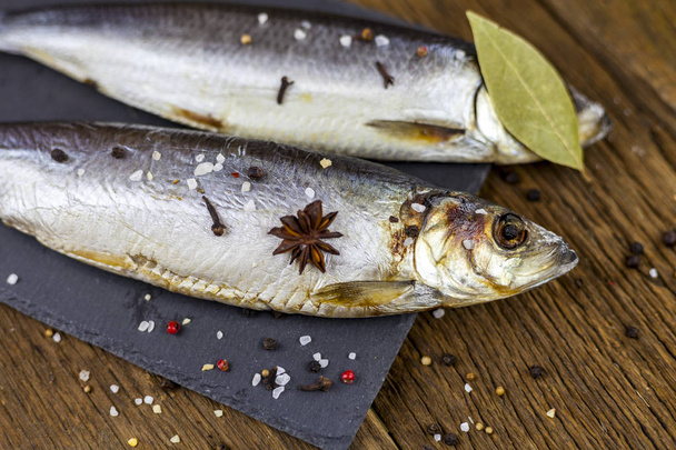 Hareng de poisson sec sur un fond en bois avec des légumes et des spécialités
 - Photo, image