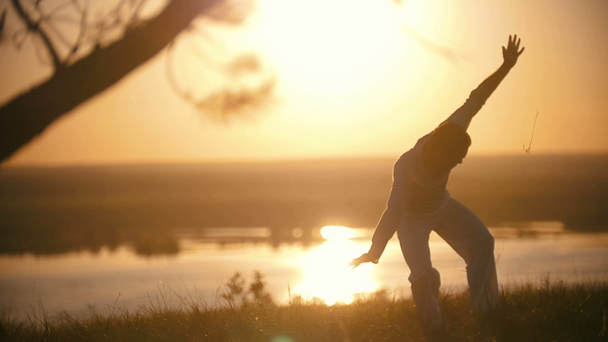 Mužské silueta účinkování vyletí na kopci na letní západ slunce - Záběry, video