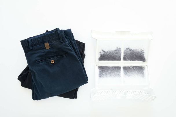 Několik snědý muž kalhoty po praní a filtr z vlasů stroj plný nečistoty, prach či vlny. Plochá ležel, horní pohled, izolované na bílém - Fotografie, Obrázek