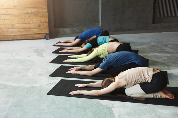 junge Frauen und Männer im Yoga-Kurs, entspannte Meditationspose - Foto, Bild