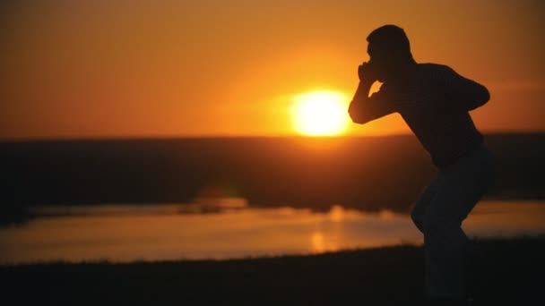 Silhueta de lutador executando truques de capoeira na colina no pôr do sol de verão
 - Filmagem, Vídeo