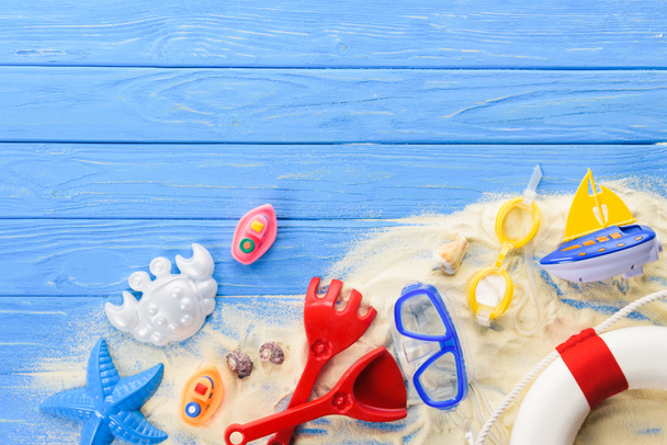 Tauchermaske und Strandspielzeug auf blauem Holzhintergrund - Foto, Bild
