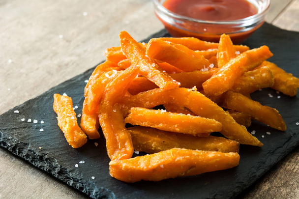 Sweet potato fries and ketchup sauce on wooden table - Photo, Image