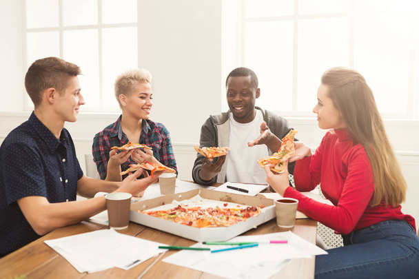 Estudiantes aprendiendo y comiendo pizza
 - Foto, imagen