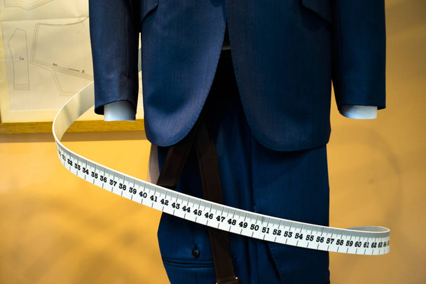 Räätäli näyteikkuna mittatilaustyönä räätälöity puku myymälä mallinukke muodollinen paita ja solmio mittanauhalla
. - Valokuva, kuva
