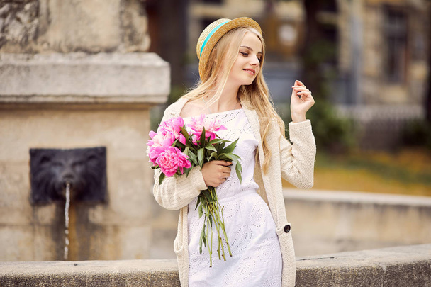 Young blonde girl with pink flowers and hat - Φωτογραφία, εικόνα
