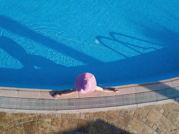 Jovem mulher tomando banho de sol em uma piscina
 - Foto, Imagem