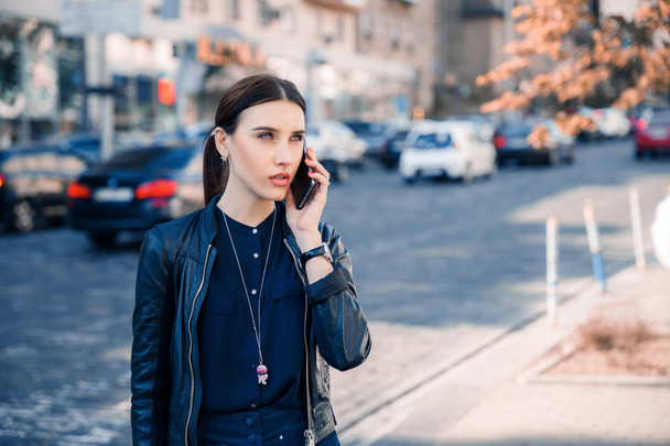 Kobieta poważne rozmowy na telefonie w mieście. Kobieta czeka na kogoś poznać - Zdjęcie, obraz