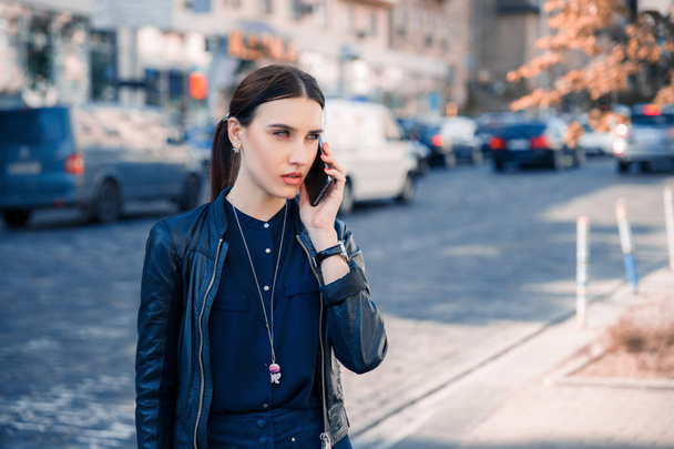 Kobieta poważne rozmowy na telefonie w mieście. Kobieta czeka na kogoś poznać - Zdjęcie, obraz