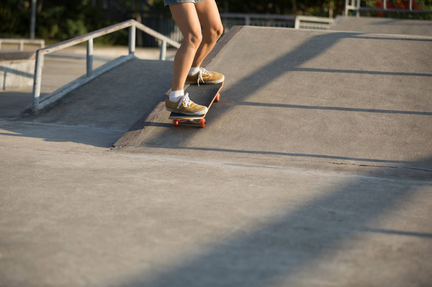 Cropped image of skateboarder skateboarding on skatepark ramp - Fotó, kép