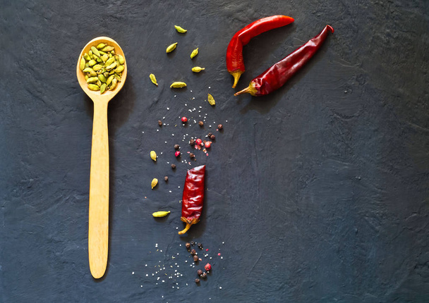 Wooden spoon and ingredients on dark background. Vegetarian food, health or cooking concept.  - Photo, Image
