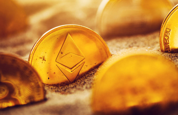 Cryptocurrency coins buried in sand, conceptual image for crypto mining and newly found treasures metaphor, selective focus - Zdjęcie, obraz