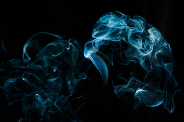 Абстрактный синий дым, выделенный на черном фоне из ароматических палочек
 - Фото, изображение