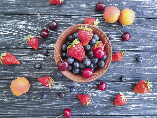 blueberry, strawberry apricot cherry on old black wooden - Foto, Imagem