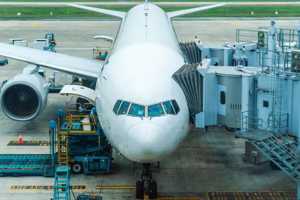 Vliegtuig parkeren op de luchthaven en de voorbereiding voor de volgende vlucht. Vliegtuigonderhoud - Foto, afbeelding